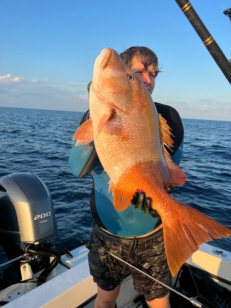 Jack on a boat holding a large dog snapper