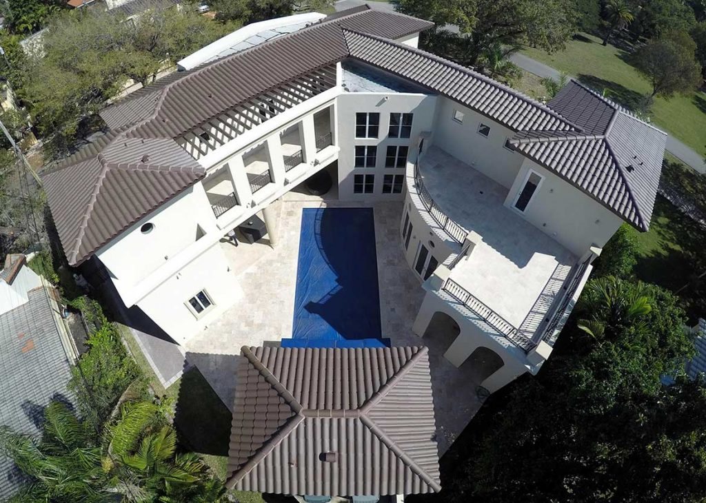 Aerial view of a home with a graphite clay tile roof and pool